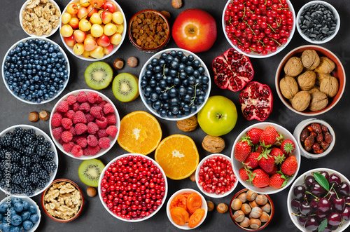 Fototapeta Naklejka Na Ścianę i Meble -  Food for a healthy diet: berries, fruits, nuts, dried fruits. Black concrete background