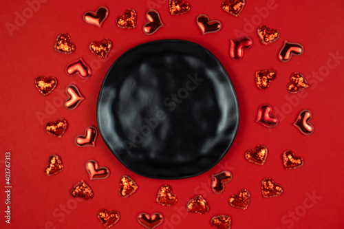 Black round plate above red hearts. Copy space