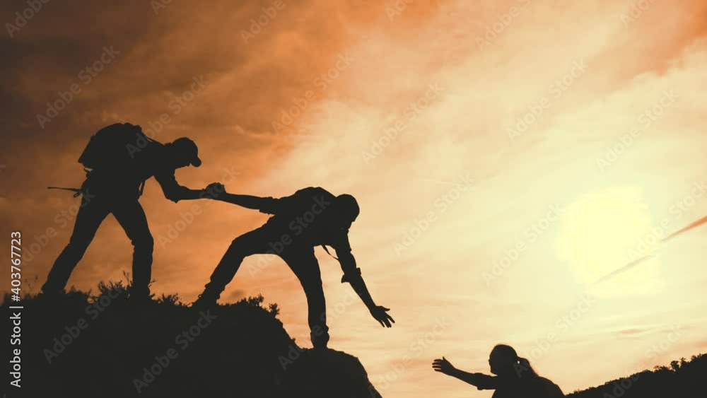 teamwork help business travel silhouette concept. group team of tourists lifestyle lends a helping hand climb the cliffs mountains. teamwork people climbers climb to top lifestyle overcoming hardships