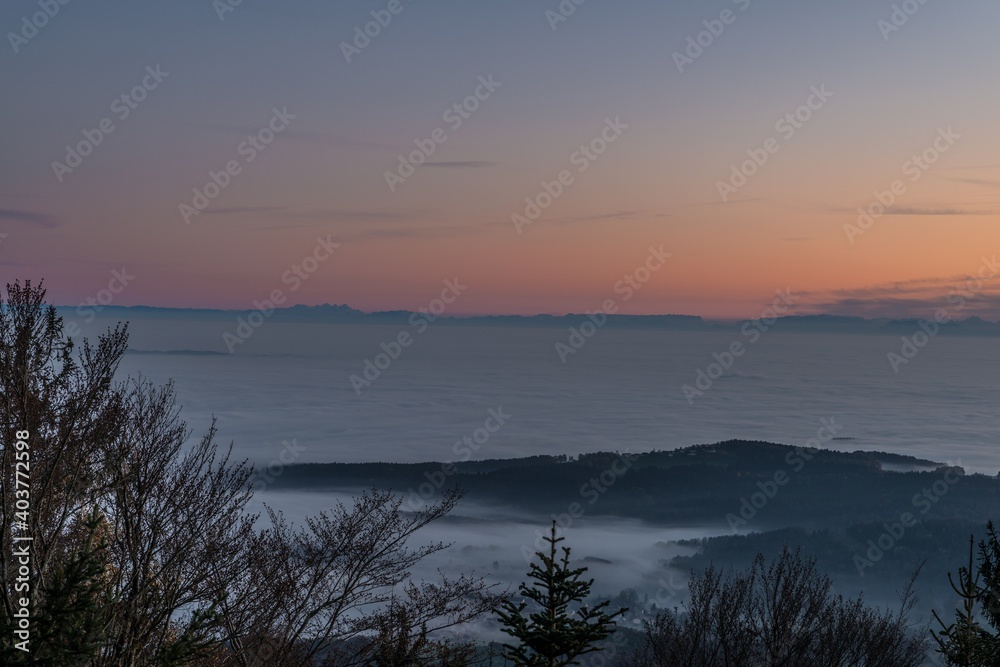 Panorama Landschaft und Sonnenuntergang mit Ausblick Blick zu den Bergen der deutschen Alpen mit Nebelmeer auf dem Geisslinger Stein beim Ruselabsatz nähe Koenigsstein im bayerischen Wald, Deutschland
