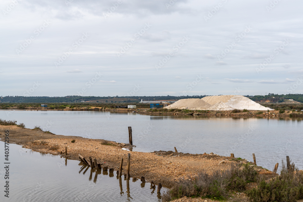 the salt flats and salines at Isla Cristina in Andalusia with a mountain of organic marine salt ready for shipping