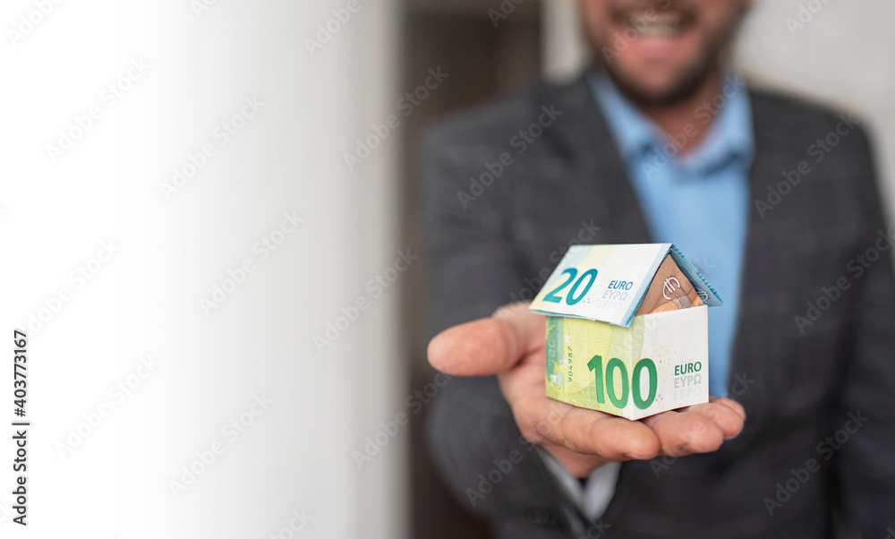 Man holding a house of bank notes Man holding a house of bank notes