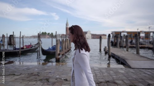 Wallpaper Mural Beautiful young woman walking with Venetian Lagoon and gondolas on the background Venice, Italy.  Torontodigital.ca