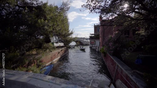 Wallpaper Mural Walking close to a canal meanwhile a boat floating in Venice Italy looking at the blue sky. Torontodigital.ca