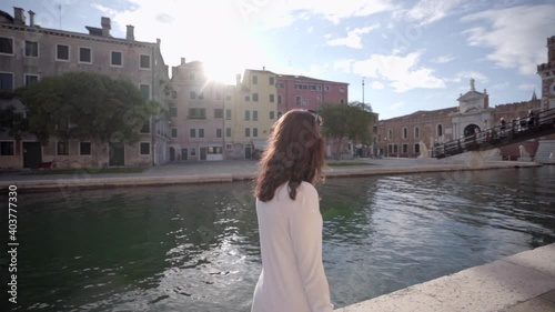 Wallpaper Mural Attractive young woman walk close to a canal in Venice Italy looking at the blue sky. Torontodigital.ca