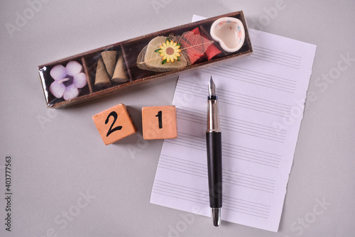 Gift case with pen and calendar boxes on white notes paper on grey background