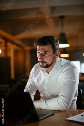 Young businessman working with laptop at office. Businessman sitting at office desk working on laptop computer..