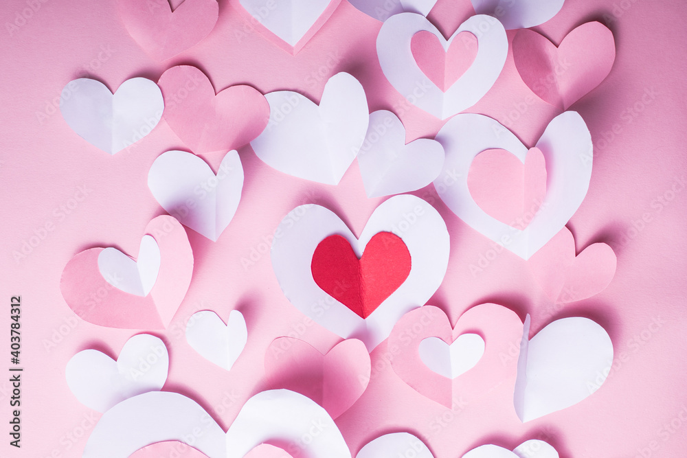 Valentine's Day festive background with pink and white paper hearts on a pink background for Valentines  holiday. Flatlay. Top view. Copyspace.