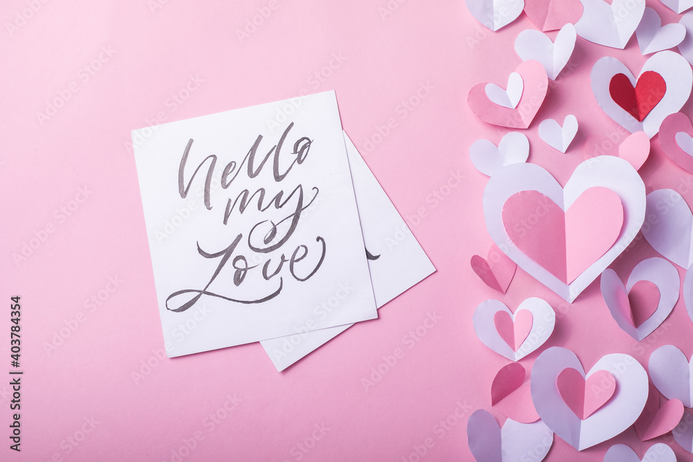 Valentine's Day festive background with pink and white paper hearts on a pink background for Valentines  holiday. Flatlay. Top view. Copyspace.