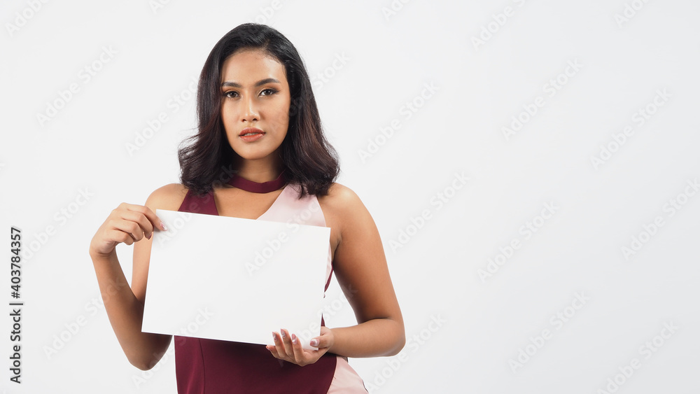 Asian beautiful young woman holding empty blank paper. A studio portrait with white background .Empty Space for text .She have tan skin. Asian beautiful young woman holding empty blank paper. A studio portrait with white background .Empty Space for text .She have tan skin.