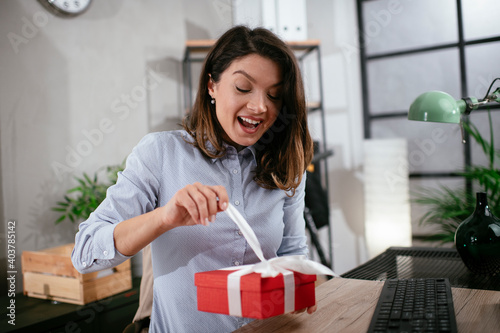 Tableau sur toile Portrait of a cheerful young businesswoman with gift