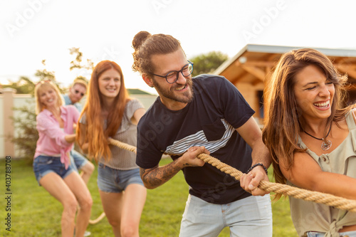 Friends playing tug of war at an outdoor summertime party