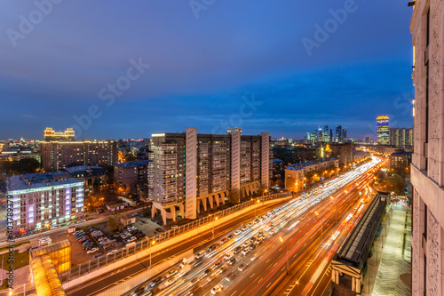  Big city lights. Moscow city business centre in the distance. Light trails of the evening road.