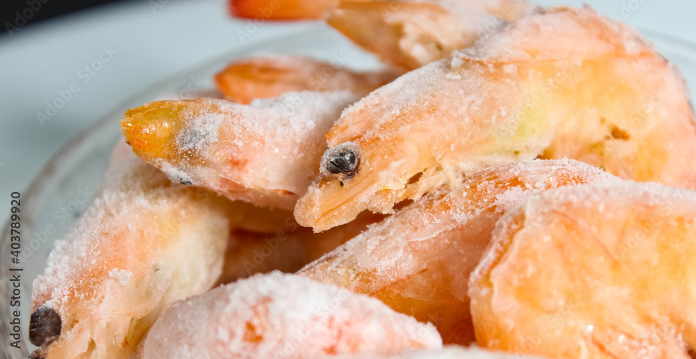 Raw frozen shrimp in a glass plate close-up. Raw frozen shrimp in a glass plate close-up.