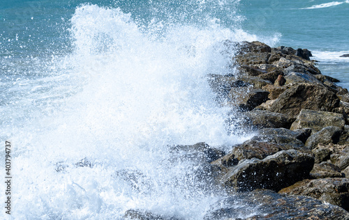 Close-up of sea waves breaking on the rocks of Vilanova y la Geltru beach