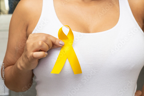 Young woman, with white t-shirt, holding yellow ribbon, prevention of suicide.