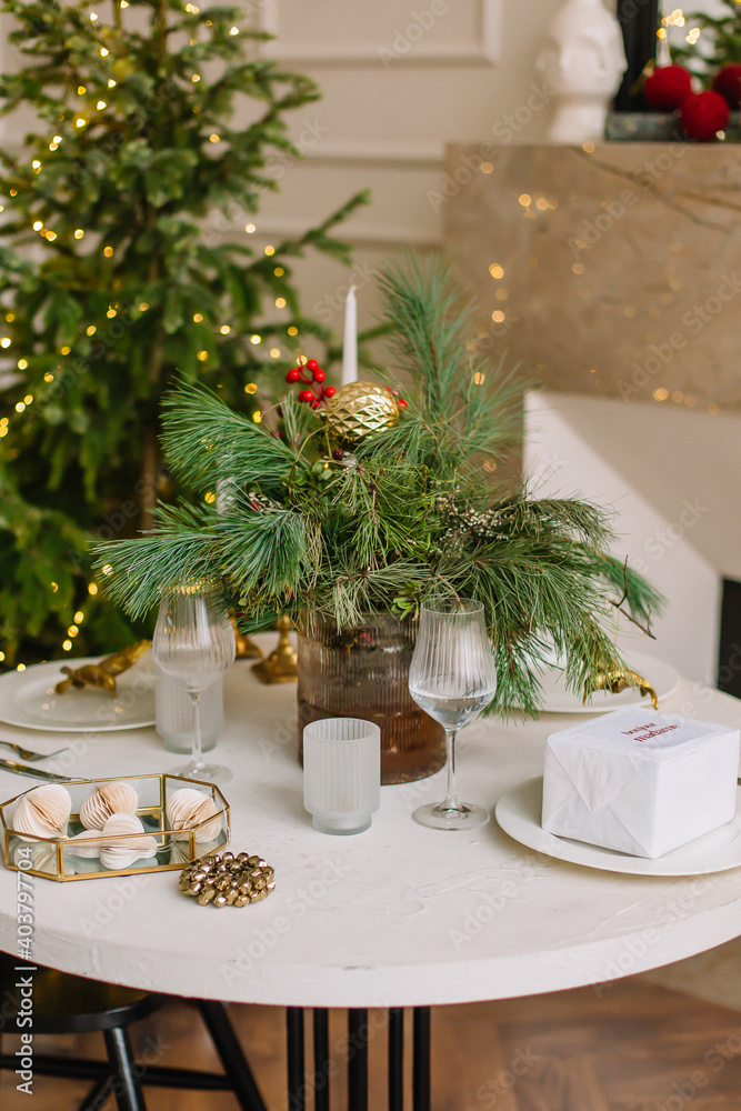 Festive table for christmas with spruce glasses and candles Festive table for christmas with spruce glasses and candles