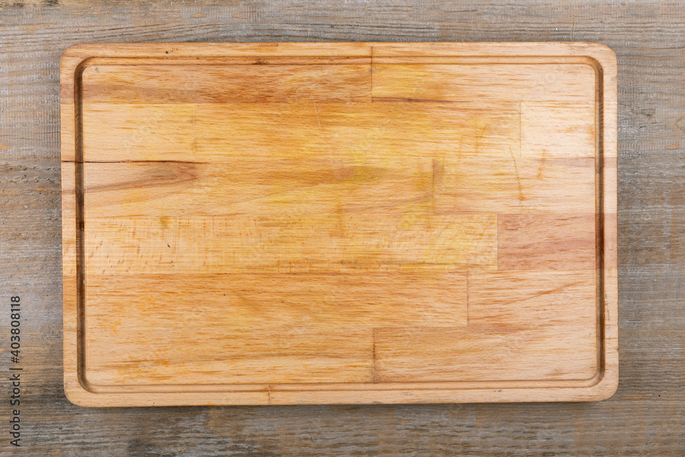Empty cutting board on a wooden table. Space for text.