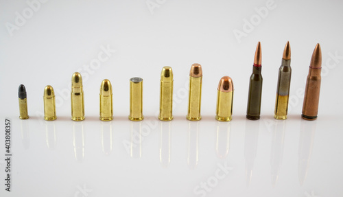 Different sized bullets comparing ammunition over white background with long shadow