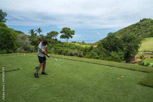 Golfer tee shot on Lemuria Golf course hole nr. 17 Resort Praslin Seychelles