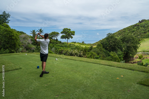 Golfer tee shot on Lemuria Golf course hole nr. 17 Resort Praslin Seychelles