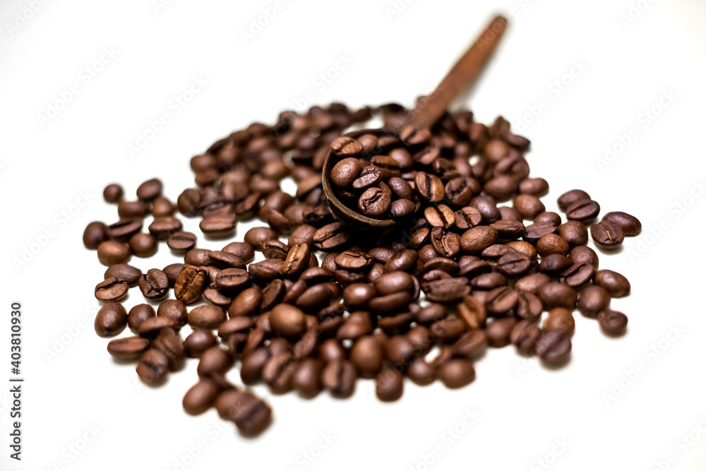 Obraz premium Coffee beans in wooden spoon. White background.