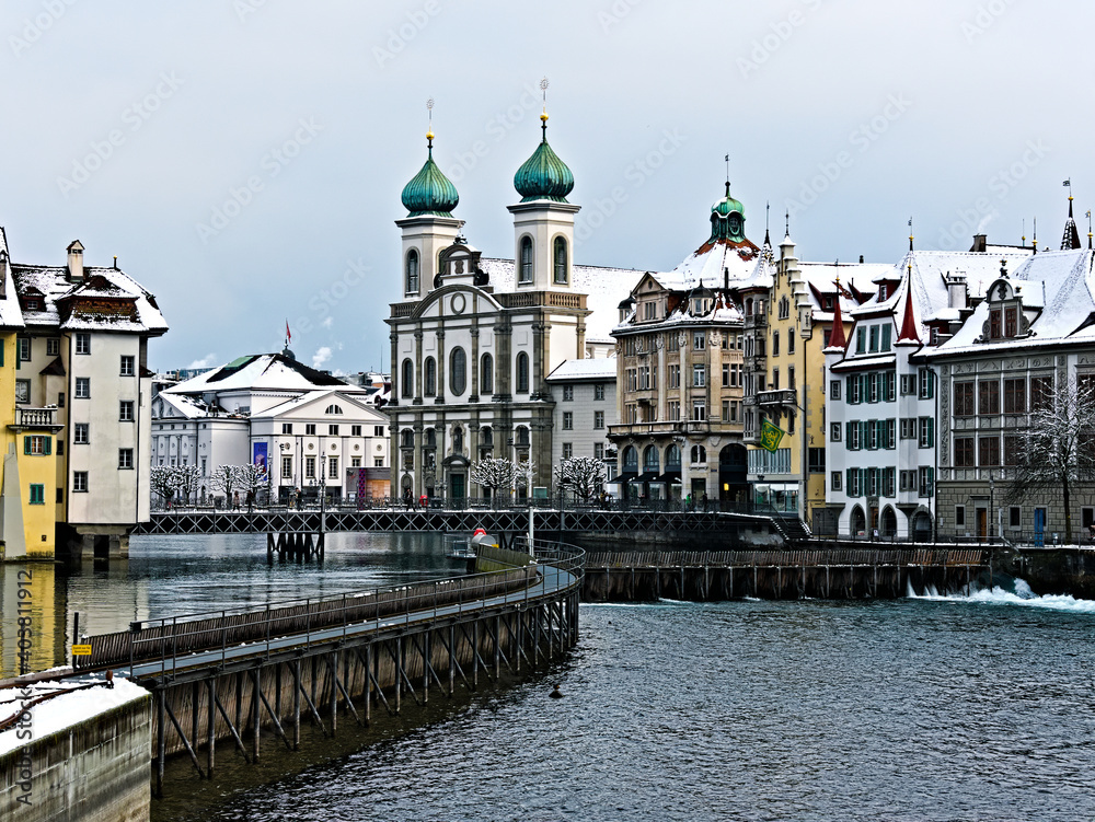 Die Jesuitenkirche im historischen Stadtzentrum von Luzern (Schweiz) mit dem Fluss Reuss und alten Gebäuden an einem Wintertag