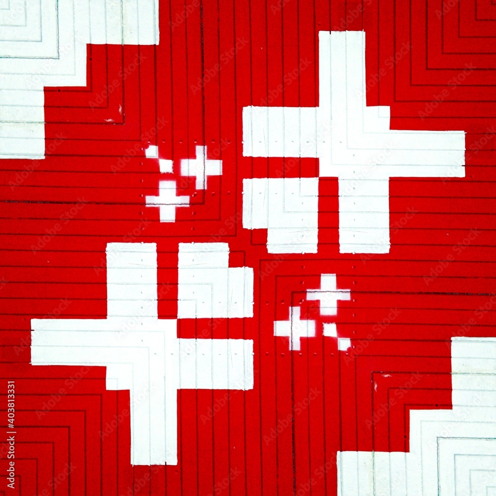 Fototapeta premium geometric shapes patterns and design from bright white plus sign on vivid red textured background