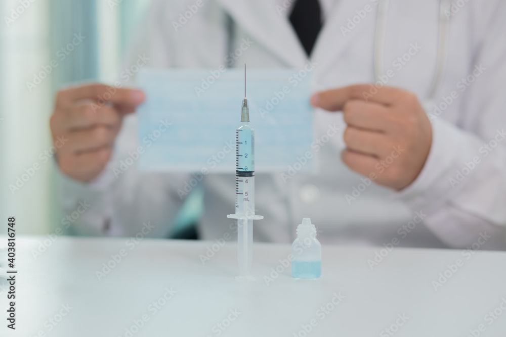 Doctor in mask taking vaccine with syringe
L Doctor in mask taking vaccine with syringe
L