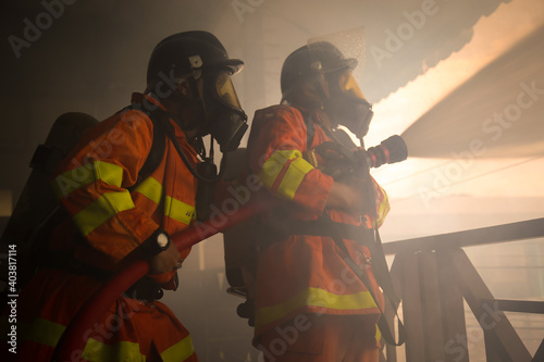 Firefighters spraying water on fire