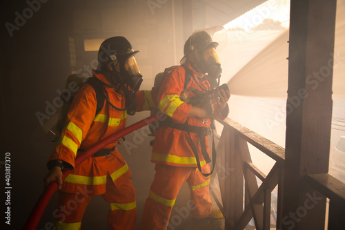Firefighters spraying water on fire