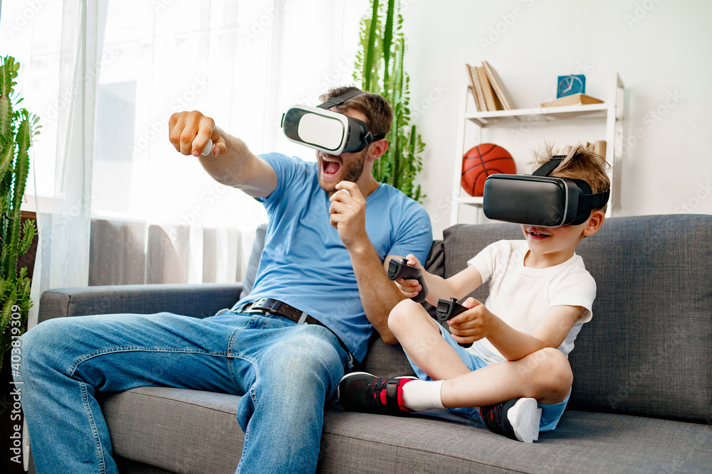 Dad son sitting on sofa and playing VR glasses Stock Photo | Adobe Stock
