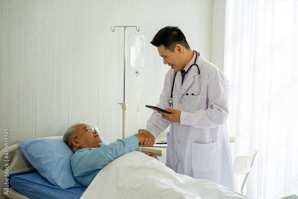 Asian medical doctor with old patient on the bed in hospital Asian medical doctor with old patient on the bed in hospital