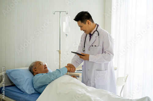 Asian medical doctor with old patient on the bed in hospital 