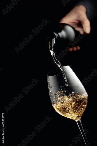 Pouring white wine in a glass goblet.