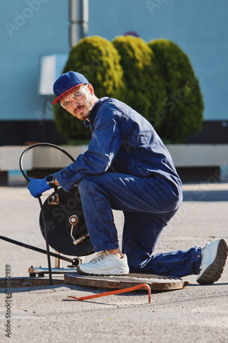 The plumber prepares to fix the problem in the sewer. Repair work on troubleshooting.