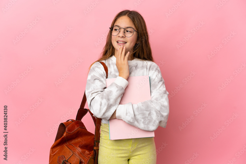Student little girl over isolated pink background looking up while smiling Student little girl over isolated pink background looking up while smiling