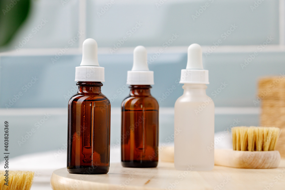 Glass cosmetic oil bottles with pipette in bathroom Glass cosmetic oil bottles with pipette in bathroom