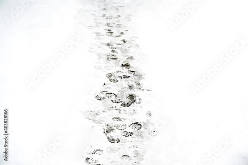 Lots of footprints in snow. Winter. Outdoors.