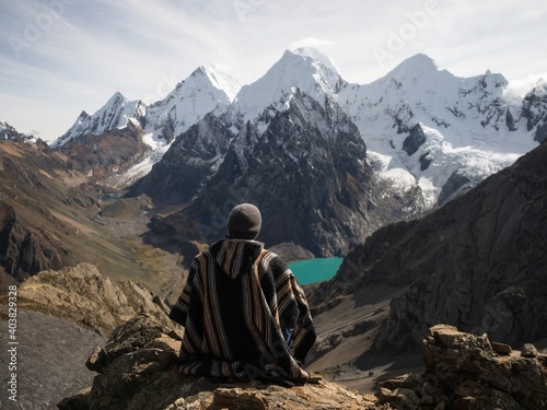 Male hiker in traditional poncho Cordillera Huayhuash Circuit andes mountain San Antonio pass Laguna Jurau Huanuco Peru photo