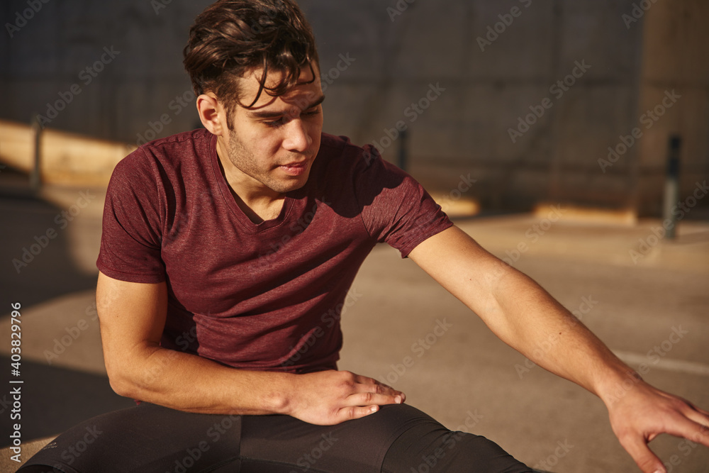 Man stretches his arm forward towards his feet Man stretches his arm forward towards his feet