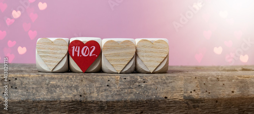 Happy Valentine's Day 14.02. background banner greeting card - Wooden cubes with heart symbol on rustic vintage wooden table texture with pink romantic bokeh lights
