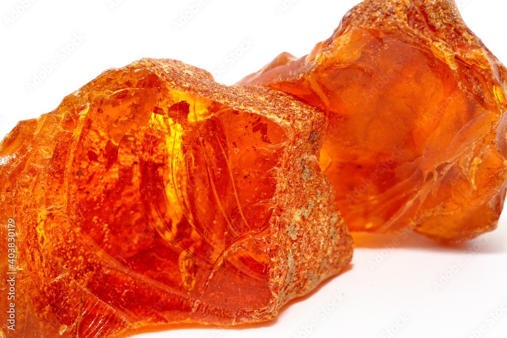 Two pieces of unique transparent yellow amber on a white background. A semi-precious stone made from petrified resin. Material for jewelry and ornaments. Copal. Sun stone. Fossil resin. Baltic gem. Two pieces of unique transparent yellow amber on a white background. A semi-precious stone made from petrified resin. Material for jewelry and ornaments. Copal. Sun stone. Fossil resin. Baltic gem.