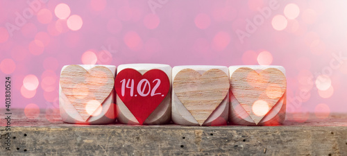 Happy Valentine's Day 14.02. background banner greeting card - Wooden cubes with heart symbol on rustic vintage wooden table texture with pink romantic bokeh lights