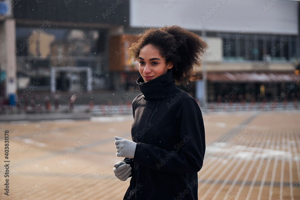 Obraz premium Athletic female jogging through an empty square