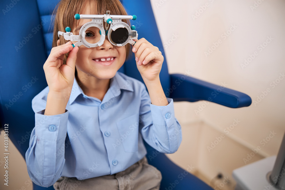 Happy kid turning the trial glasses levers Happy kid turning the trial glasses levers