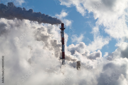 industrial chimneys with heavy smoke causing pollution on the blue sky background