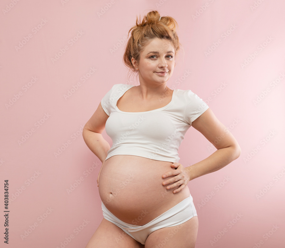 Pregnant woman holding her belly and smiling Pregnant woman holding her belly and smiling