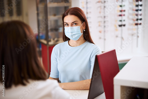 Adult wearing medical mask having a chat with a medic