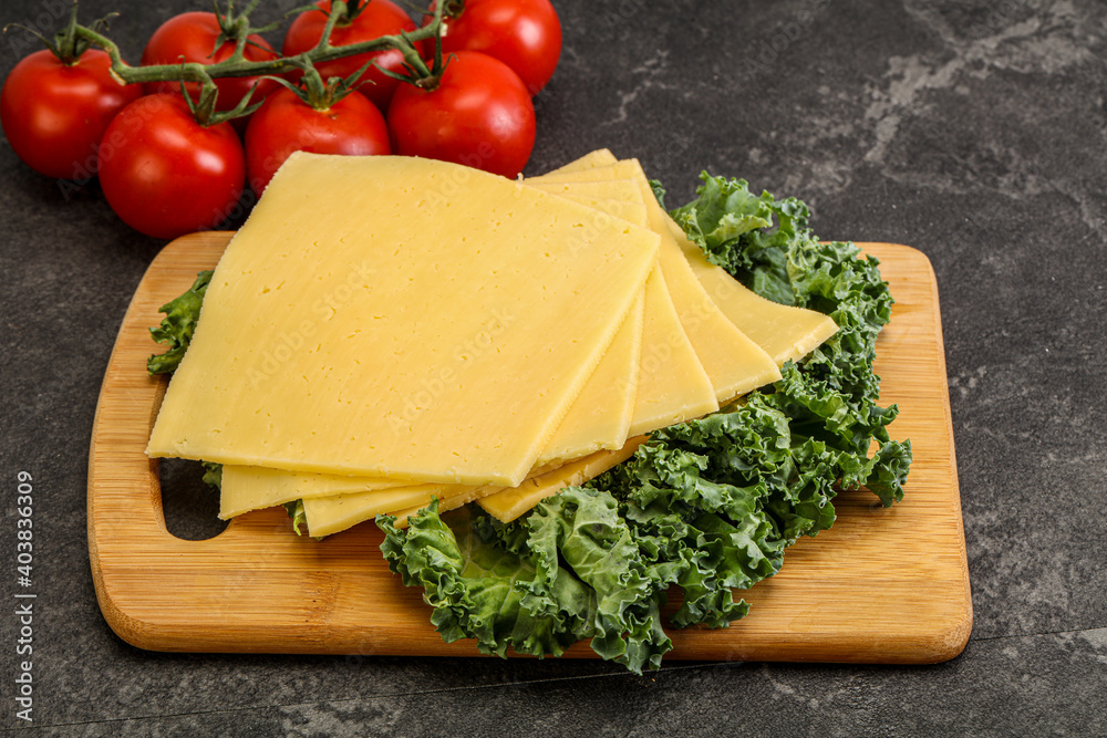 Sliced Gauda cheese over board Sliced Gauda cheese over board